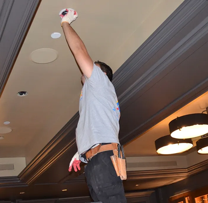 A man in blue shirt playing wii while standing on one leg.
