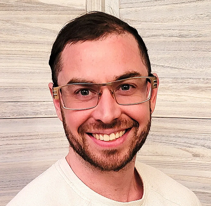 A man with glasses smiling for the camera.
