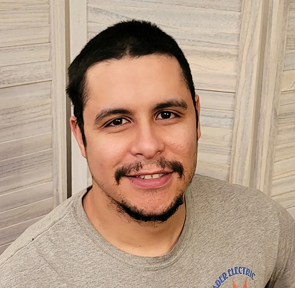 A man with a beard and mustache wearing a gray shirt.